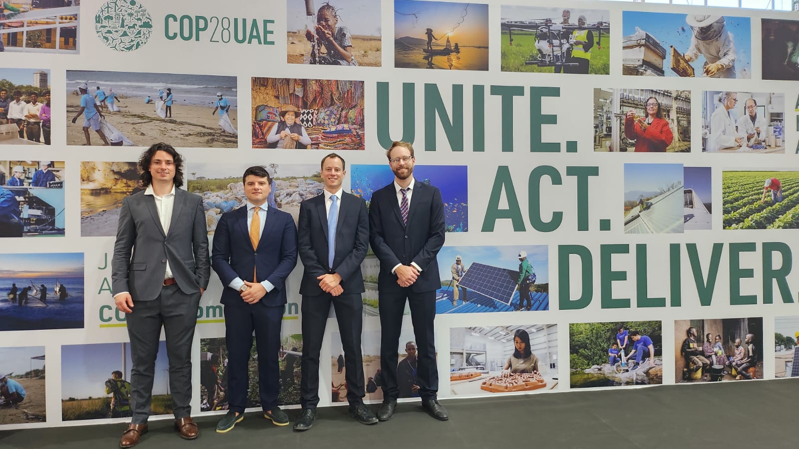 Giorgio Alessandro Donà-Danioni with the KlimaDAO delegation at COP28 UAE, photographed in front of the UNFCCC 'Unite. Act. Deliver.' wall at Expo City Dubai