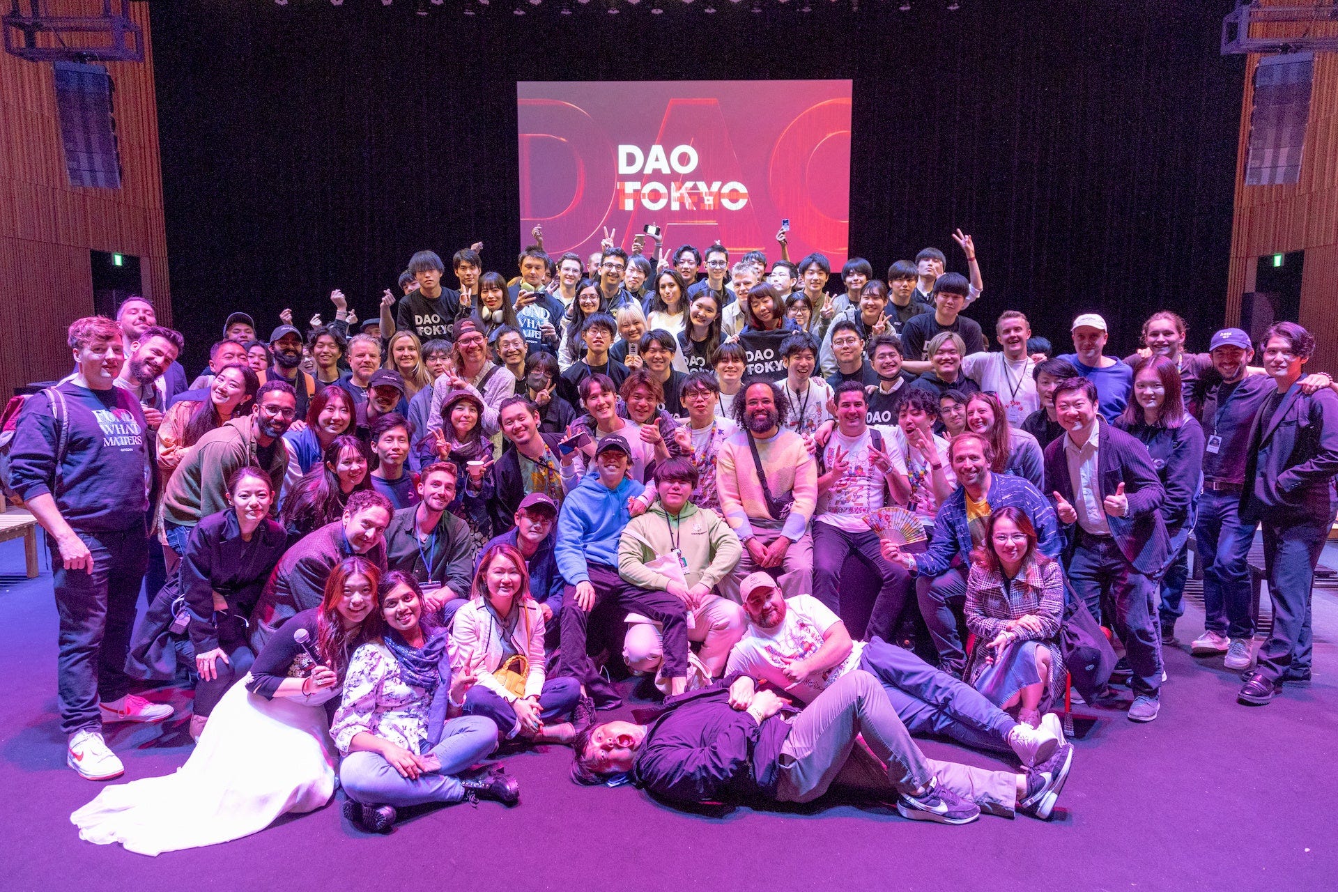 DAO Tokyo 2023 group photo with attendees and the DAO TOKYO screen, Kanda Myojin Hall, Tokyo